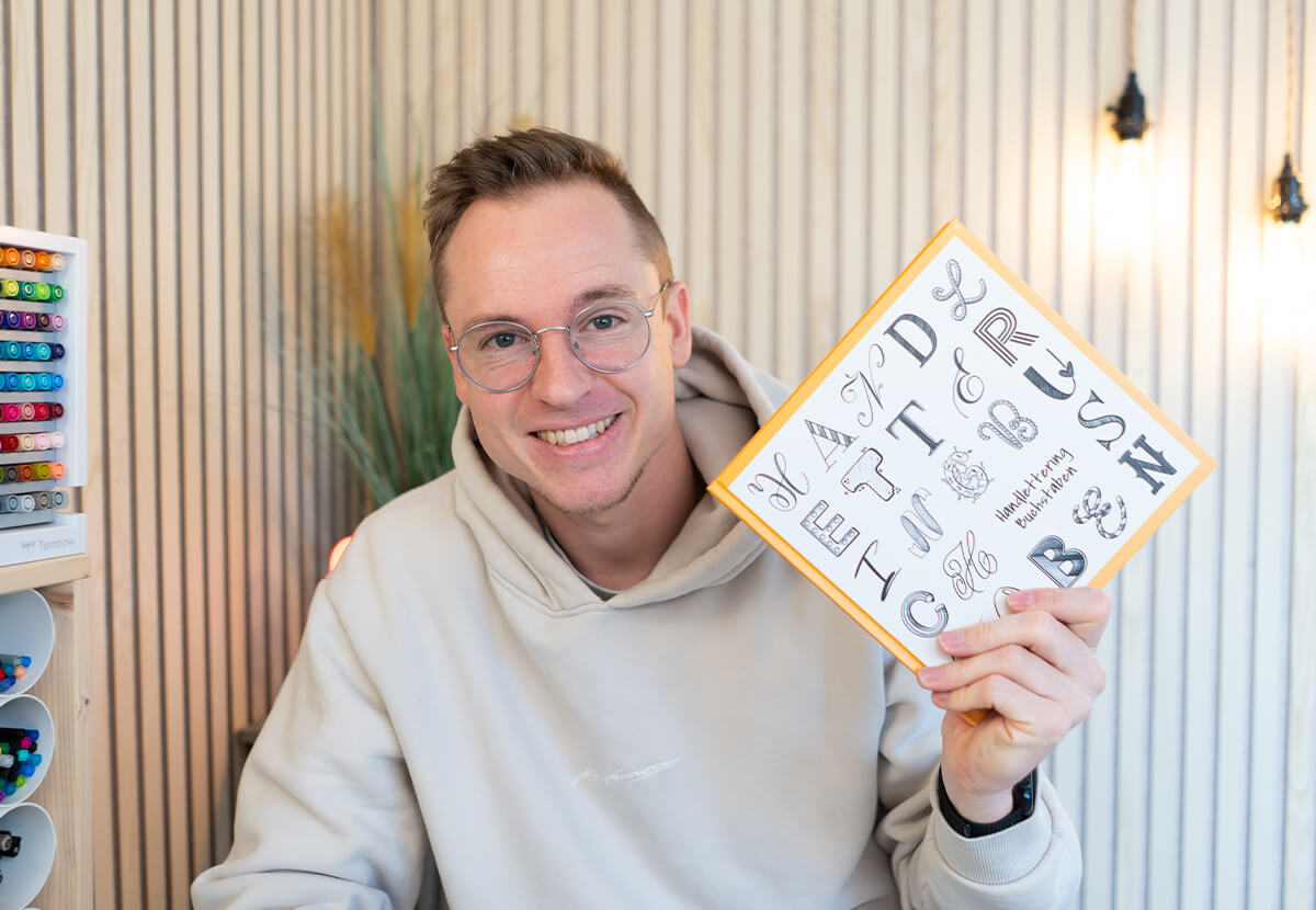 Timo Ostrich mit Handlettering-Buch